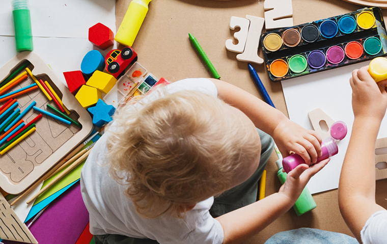 Children drawing and making crafts in kindergarten or daycare.